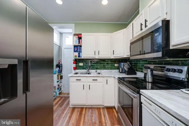 a kitchen with stainless steel appliances granite countertop a stove a sink and a refrigerator