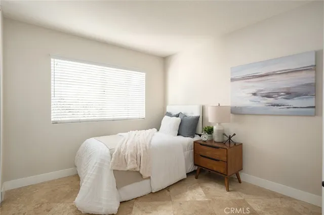a bedroom with bed and large windows