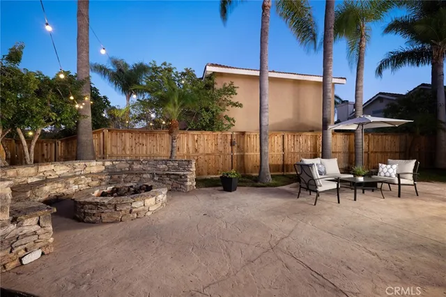 a view of a patio with table and chairs under an umbrella with palm trees