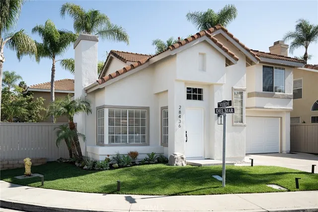 a front view of a house with a yard and potted plants