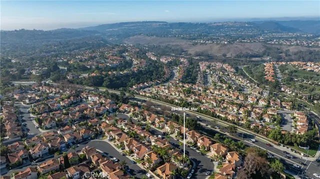 an aerial view of a house with garden space and trees all around