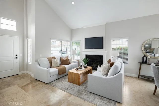 a living room with furniture a fireplace and a flat screen tv