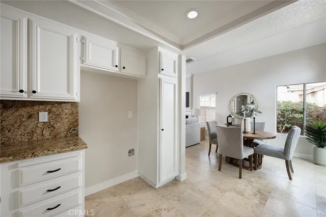 a kitchen with white cabinets appliances and a window