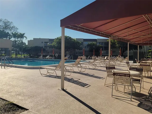 a view of a patio with a table and chairs under an umbrella