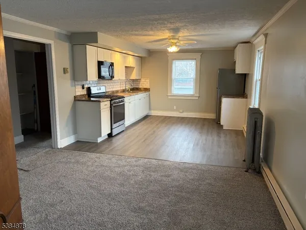 a kitchen with stainless steel appliances a stove top oven a sink and a microwave