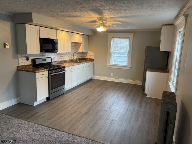 412 South Valley Road Orange, NJ 07050 - Photo 17 of 18 a kitchen with stainless steel appliances a stove top oven a sink and a microwave