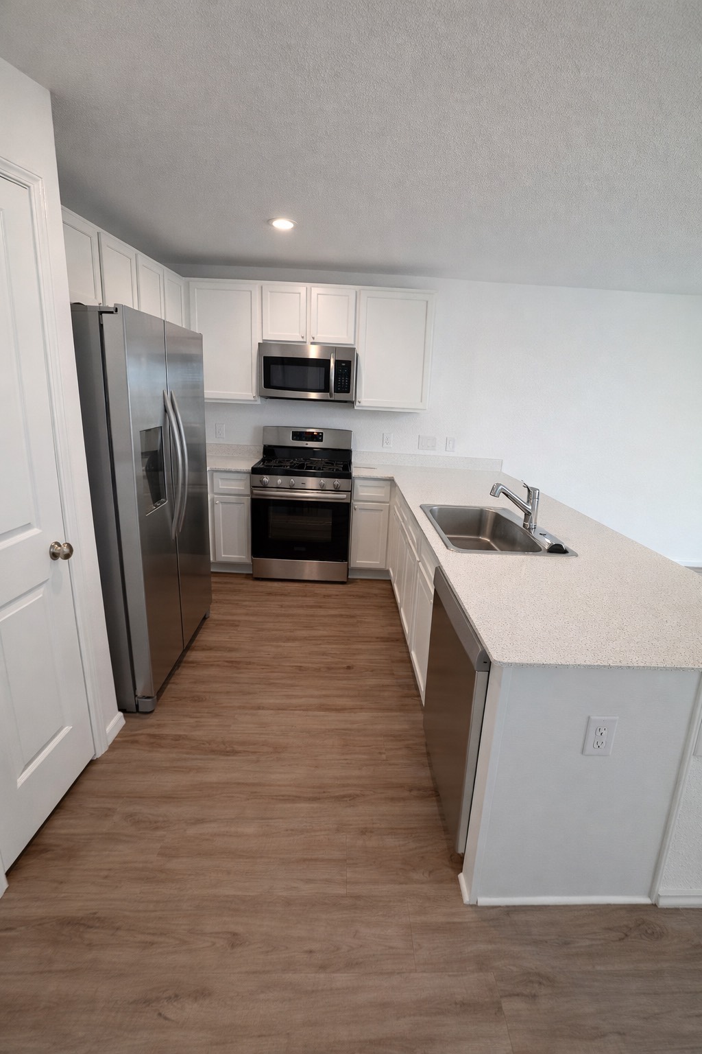1315 Millers Pass Drive Rosenberg, TX 77471 - Photo 4 of 10 a kitchen with a sink a microwave a refrigerator and cabinets