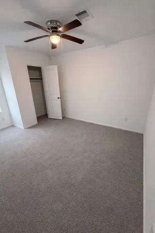 an empty room with a fan and a ceiling fan