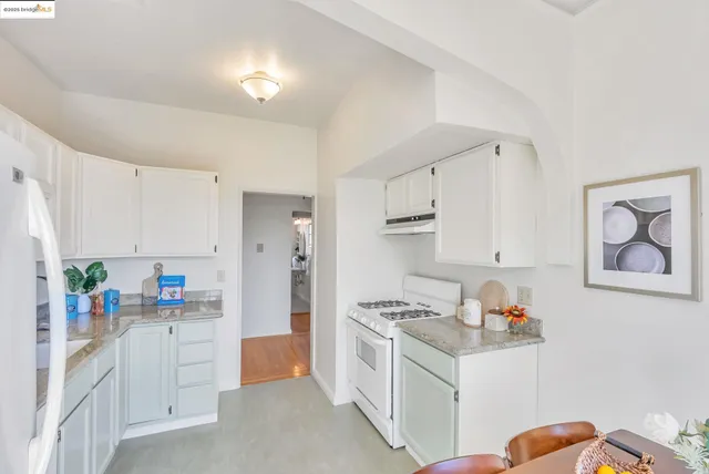 a kitchen with white cabinets and white appliances
