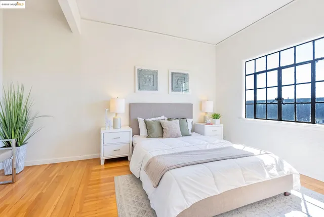 a bedroom with a large bed and a potted plant