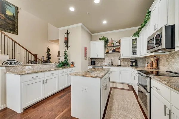 a kitchen with stainless steel appliances granite countertop a sink and cabinets