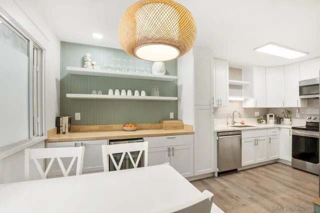 a kitchen with a stove a sink a dining table and chairs
