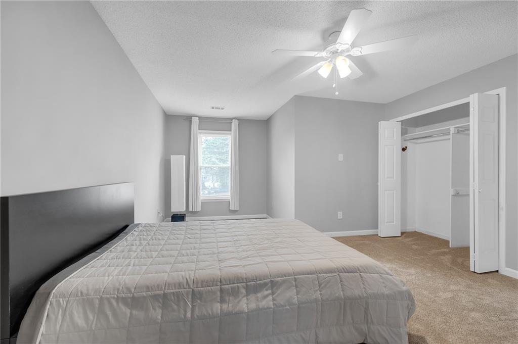 1206 Defoor Court Northwest, Unit 2A Atlanta, GA 30318 - Photo 20 of 36 a bedroom with a large bed and a chandelier