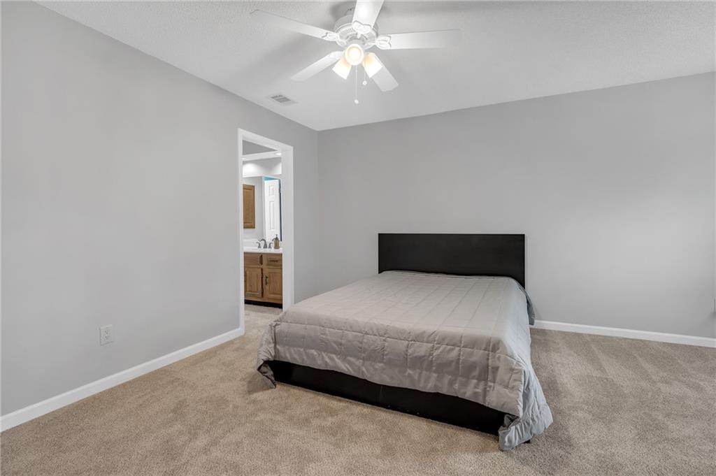 1206 Defoor Court Northwest, Unit 2A Atlanta, GA 30318 - Photo 21 of 36 a bedroom with a bed and a chandelier