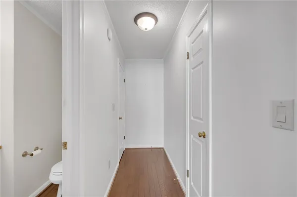 a view of a hallway with wooden floor and closet