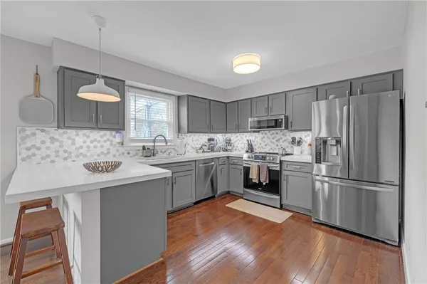 a kitchen with a sink refrigerator and microwave