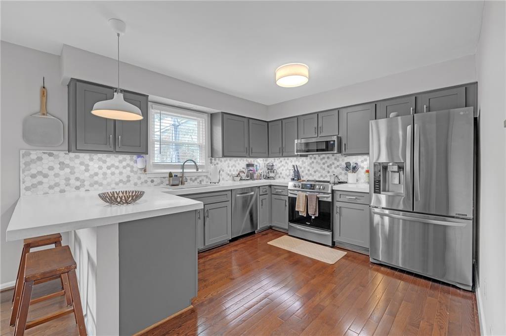 1206 Defoor Court Northwest, Unit 2A Atlanta, GA 30318 - Photo 7 of 36 a kitchen with a sink refrigerator and microwave