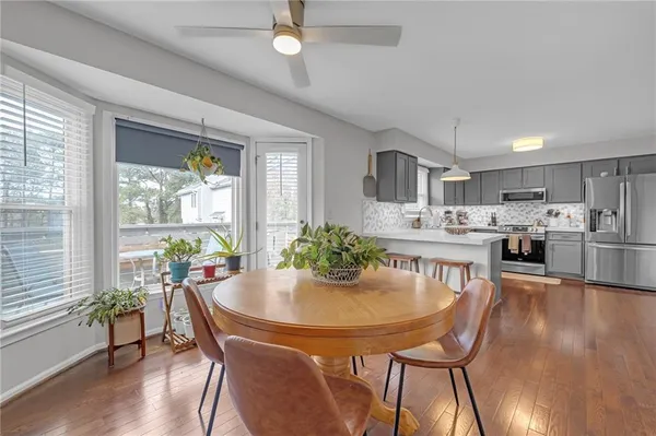 a kitchen with a dining table chairs and refrigerator