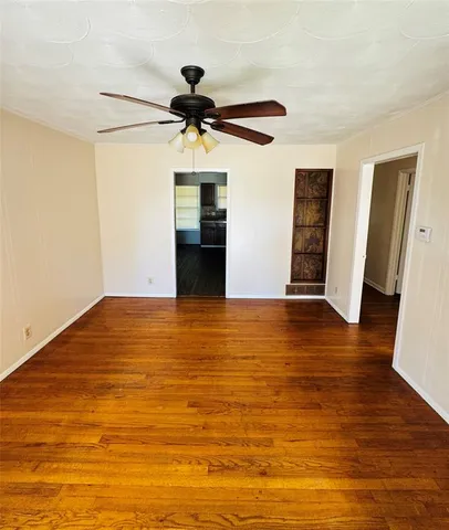 a view of a room with wooden floor and ceiling fan