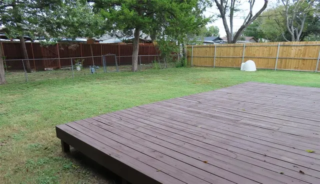 a view of a backyard with wooden fence
