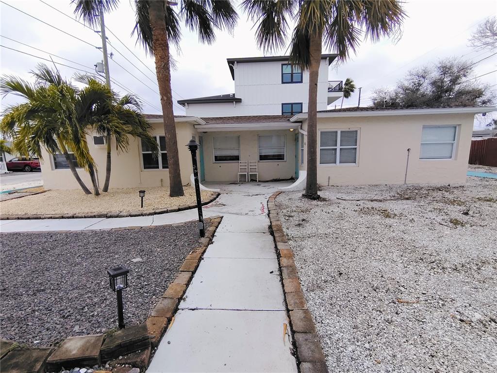 115 145th Avenue, Unit 3 Madeira Beach, FL 33708 - Photo 1 of 12 front view of house with a palm tree