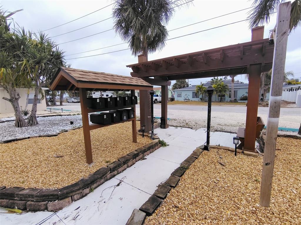 115 145th Avenue, Unit 3 Madeira Beach, FL 33708 - Photo 12 of 12 a front view of a building with small garden