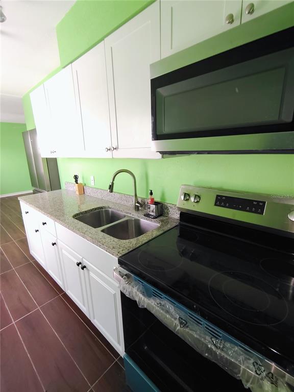 115 145th Avenue, Unit 3 Madeira Beach, FL 33708 - Photo 9 of 12 a kitchen with a stove and a microwave