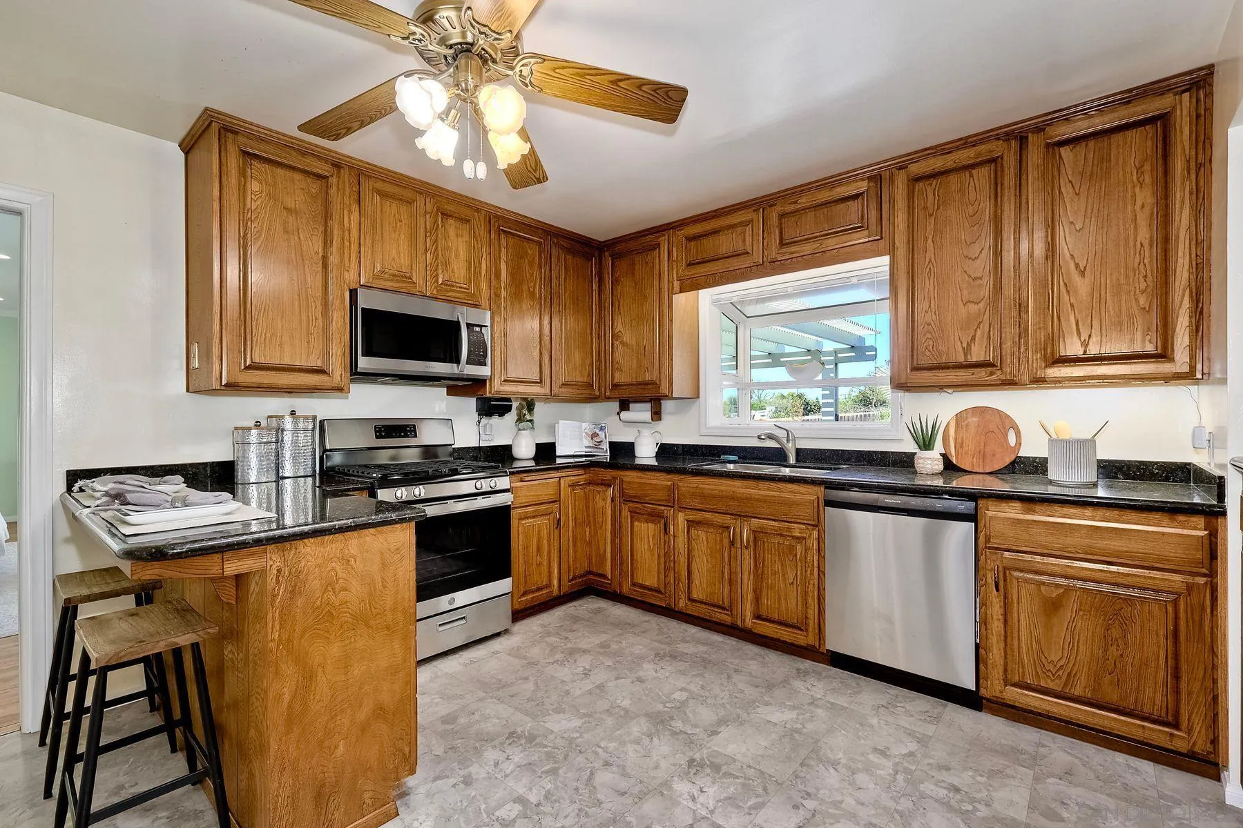 1346 Pepper Villa Drive El Cajon, CA 92021 - Photo 6 of 25 a kitchen with stainless steel appliances granite countertop wooden cabinets a stove top oven a sink and dishwasher