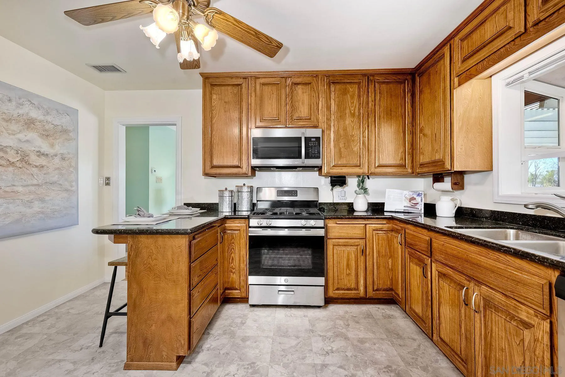 1346 Pepper Villa Drive El Cajon, CA 92021 - Photo 7 of 25 a kitchen with stainless steel appliances granite countertop a stove top oven a sink dishwasher and a microwave oven with cabinets