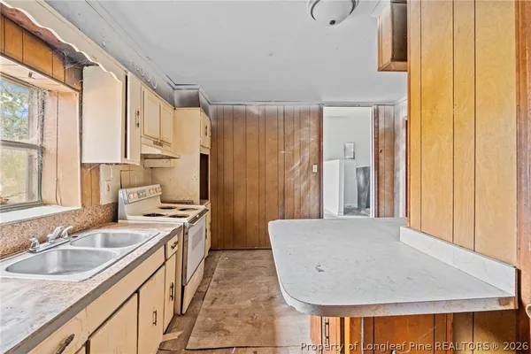 a kitchen with a sink a window and cabinets