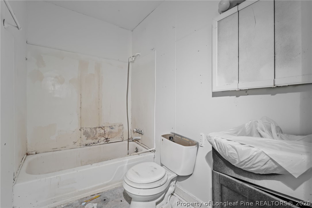217 South Grove Avenue Rockingham, NC 28379 - Photo 19 of 37 a bathroom with a granite countertop sink a toilet and bathtub