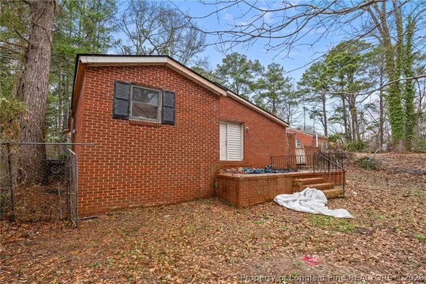 a backyard of a house with wooden fence and large trees