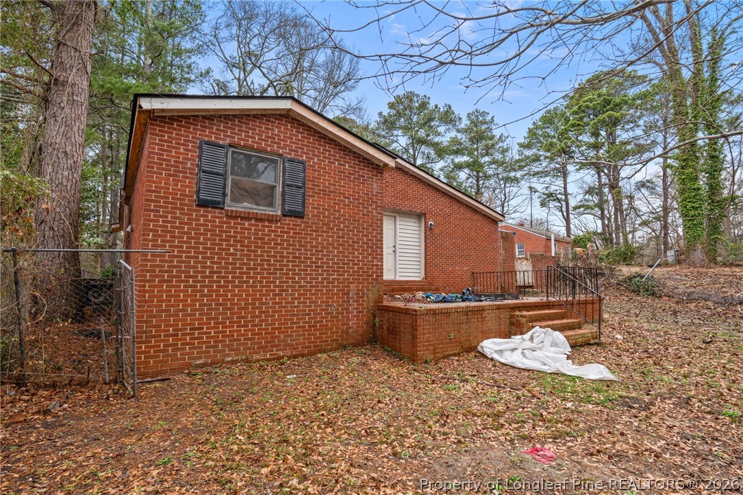 217 South Grove Avenue Rockingham, NC 28379 - Photo 30 of 37 a backyard of a house with wooden fence and large trees
