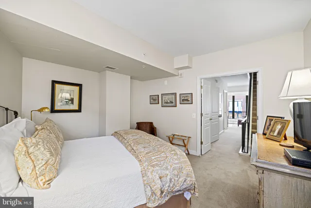 a bedroom with a bed and large windows