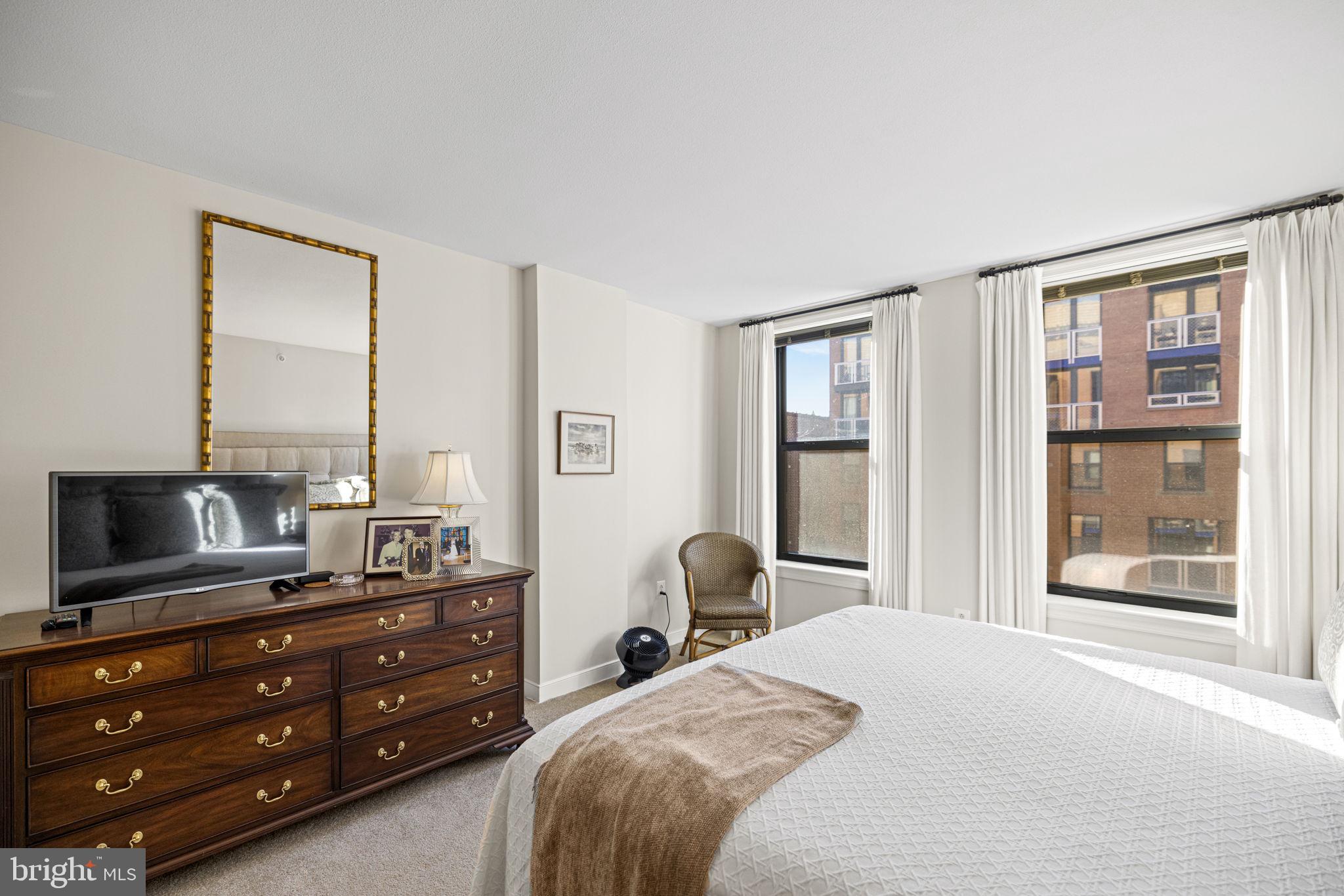 616 E Street Northwest, Unit 1152 Washington, DC 20004 - Photo 21 of 92 a bedroom with a bed and large windows
