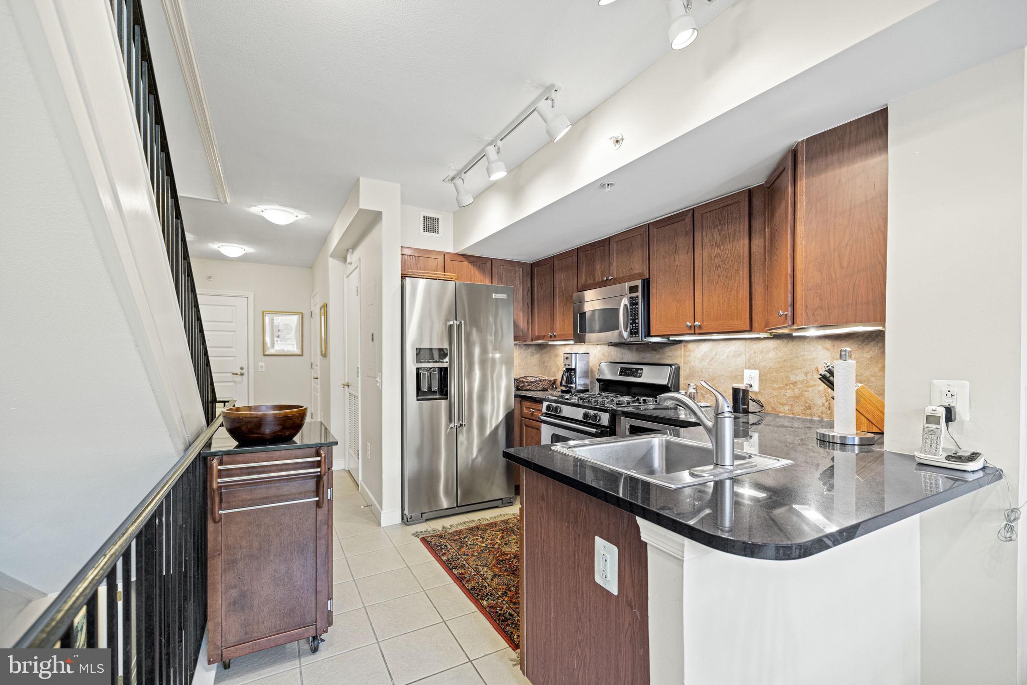616 E Street Northwest, Unit 1152 Washington, DC 20004 - Photo 6 of 92 a kitchen with stainless steel appliances granite countertop a sink stove and refrigerator