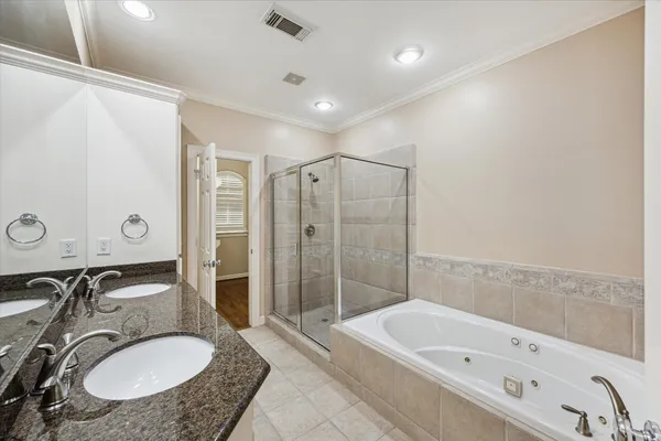 a bathroom with a granite countertop tub sink and mirror