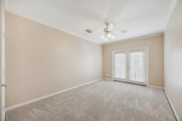 an empty room with windows and ceiling fan