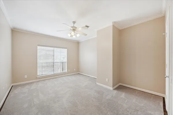 an empty room with windows and ceiling fan