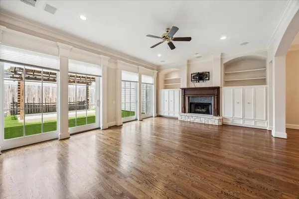 a view of empty room with wooden floor and fireplace