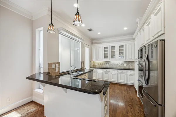 a kitchen with stainless steel appliances granite countertop a sink a stove and a refrigerator