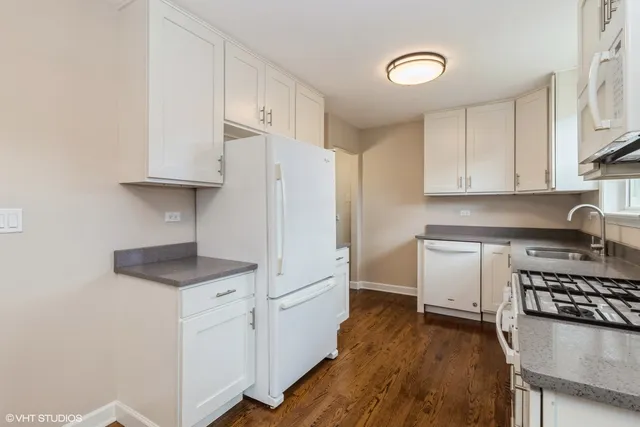 a kitchen with granite countertop a sink cabinets and stainless steel appliances