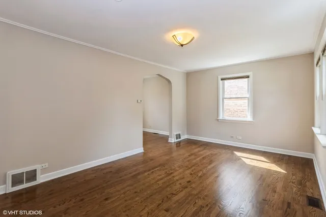 an empty room with wooden floor and window