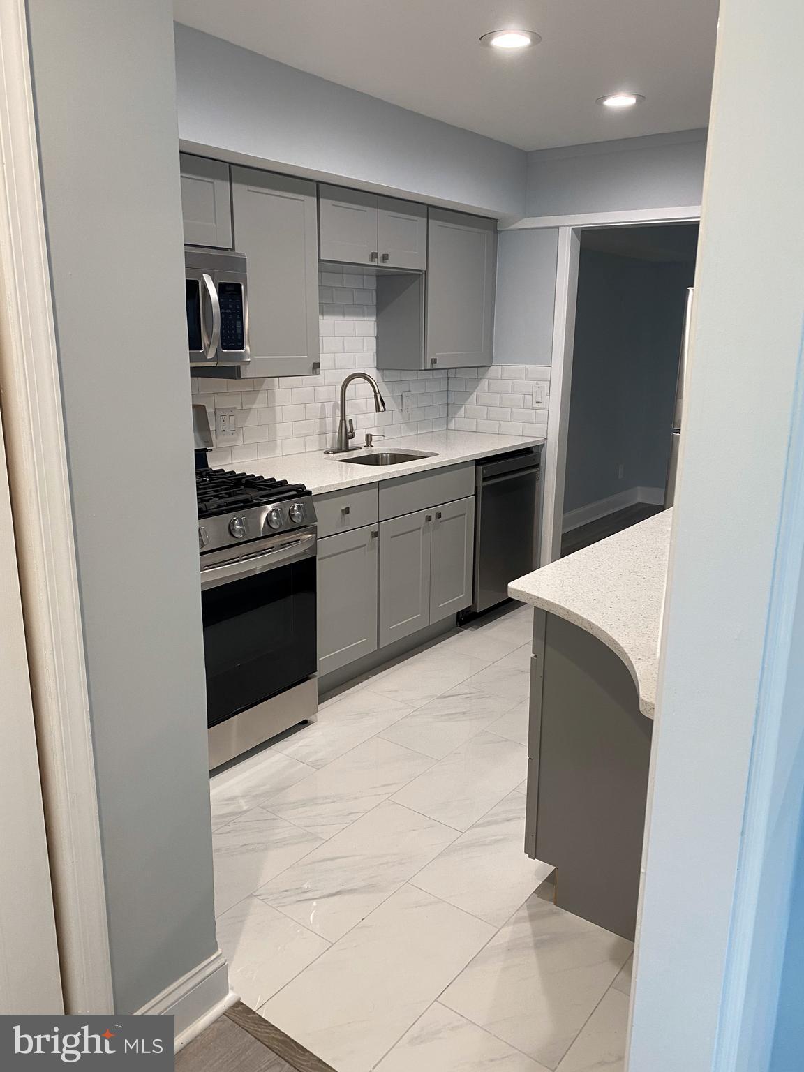 7515 Spring Lake Drive, Unit D2 Bethesda, MD 20817 - Photo 4 of 8 a kitchen with stainless steel appliances a sink stove and refrigerator