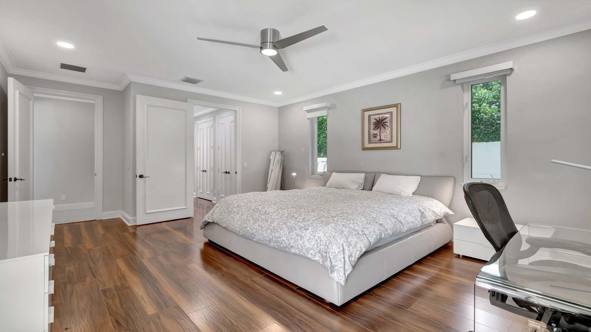 514 Northwest 13th Street Delray Beach, FL 33444 - Photo 18 of 35 a spacious bedroom with a bed and a chandelier