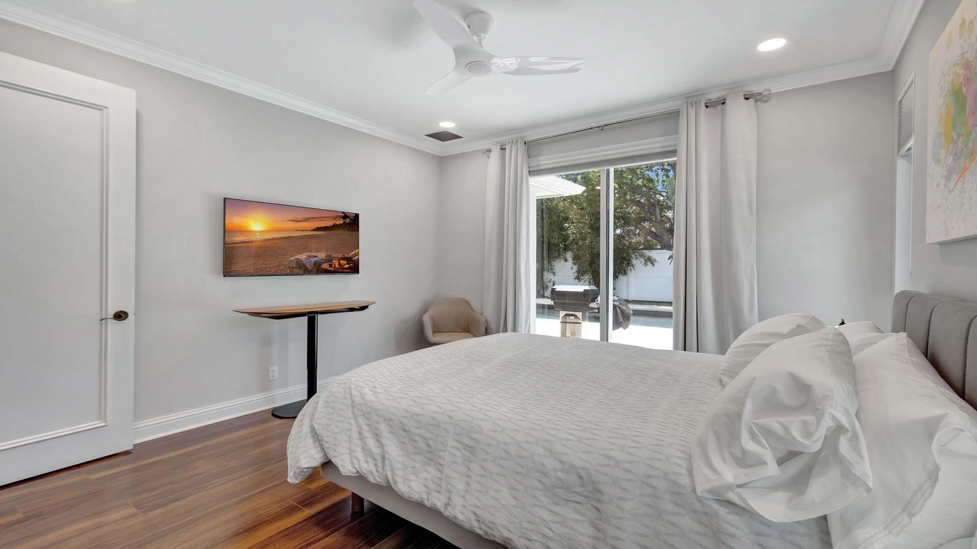514 Northwest 13th Street Delray Beach, FL 33444 - Photo 22 of 35 a bedroom with a bed and a flat screen tv