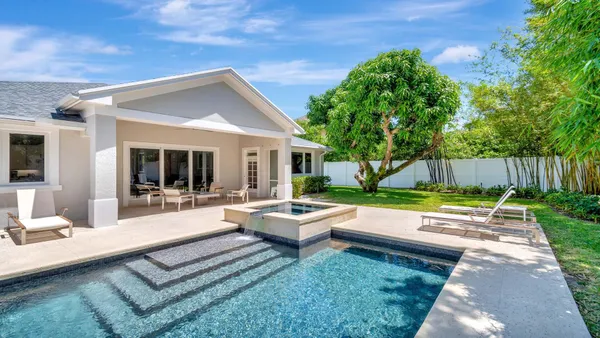 a view of a house with swimming pool and a small yard