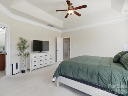 a bedroom with a bed flat screen tv and a window