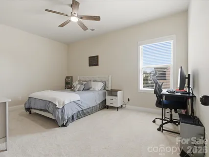 a bedroom with a bed desk and a window