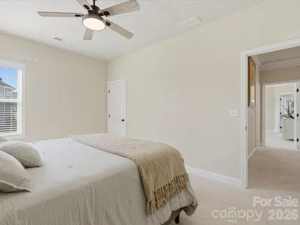 a bedroom with a bed and painting on the wall